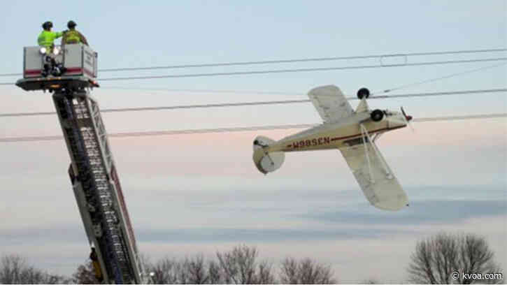 Photos show plane precariously dangling upside down from power lines in Minnesota