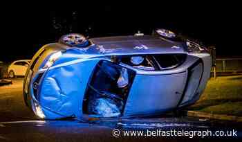 Watch: Suspected stolen car overturns at west Belfast roundabout