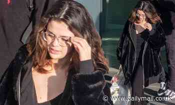 Selena Gomez goes make-up free and wraps up in a plush black jacket as she arrives in London