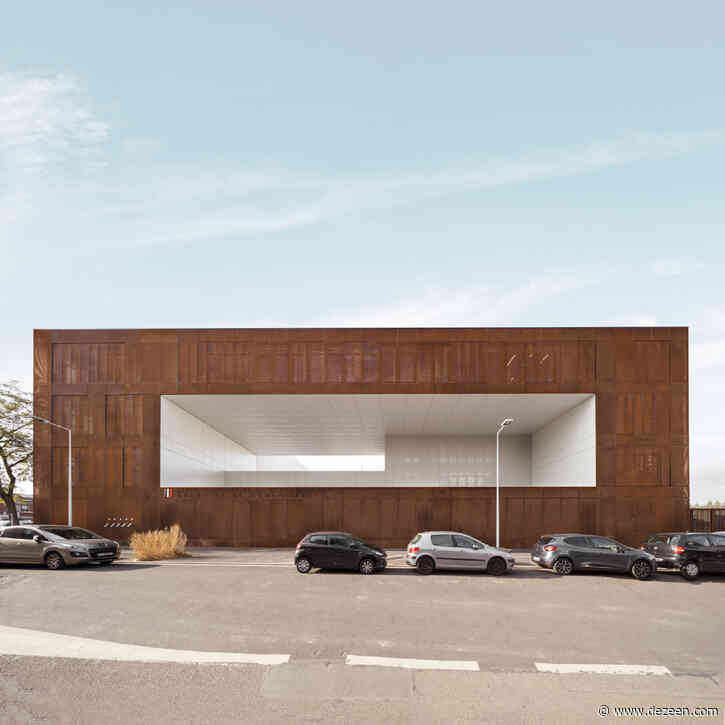 Prison clad in perforated weathering steel has pastel-coloured sports court