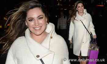 Kelly Brook wraps up in a white coat as she leaves Global Radio Studios toting a bouquet of flowers