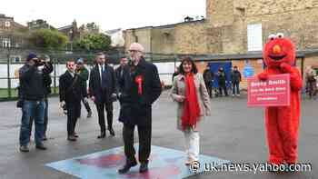 Protester dressed as Elmo greets Jeremy Corbyn at polling station