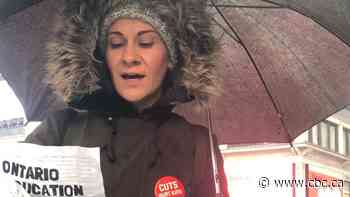 Protesters singing in the rain downtown against cuts to education