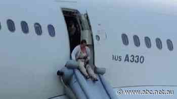 Qantas passengers use emergency slides to evacuate plane at Sydney Airport