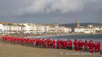 In Pictures: Pudding pursuit sees Santas take to the beach
