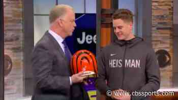 Heisman winner Joe Burrow reacts after receiving a Bengals helmet from former NFL MVP Boomer Esiason