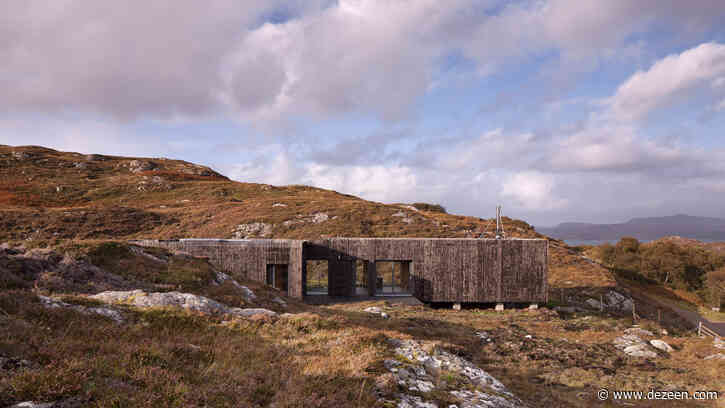 House clad in burnt larch perches on a rocky site in the Scottish Highlands
