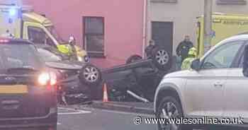 Car lands right next to front door of house after overturning on residential street in Carmarthen