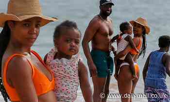 Gabrielle Union makes a splash in bright orange bikini as she cuddles daughter Kaavia