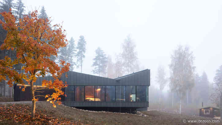 Black timber and zinc house with sauna sits next to a Finnish lake