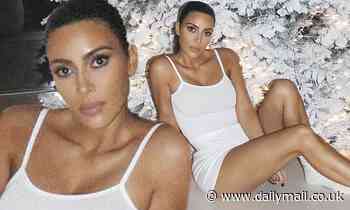 Kim Kardashian strikes a pose in her Skims loungewear while in front of her Christmas tree