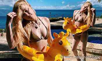 Amber Heard poses by pool with a giraffe rubber ring in Hawaii