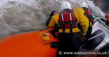 Rescuers battle huge waves to save surfer stranded in rough seas in heart-stopping footage