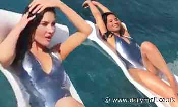 Olivia Munn shows off her slender figure in a plunging silver swimsuit for a photo shoot