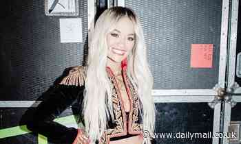 The Masked Singer: Rita Ora flaunts her toned abs in a plunging military-inspired jacket