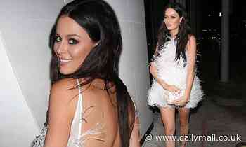 Pregnant Nicole Trunfio covers her baby bump in a backless feather dress