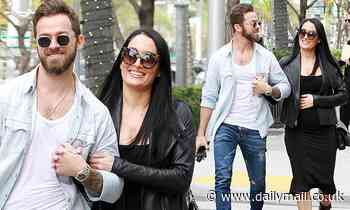 Nikki Bella touches her growing bump as she puts on loved-up display with fiance Artem Chigvintsev