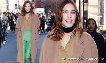 Alex Chung looks chic in a tan coat and eye-catching green trousers