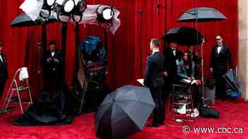 Oscars night begins with downpour over red carpet