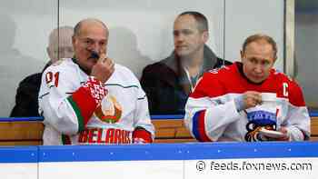 Vladimir Putin enjoys a drink during hockey match with Belarus' president