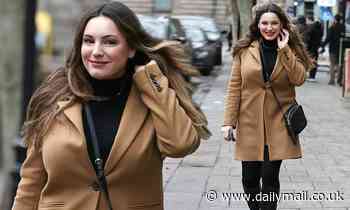 Kelly Brook is classically stylish in a camel coat and knee high boots as she heads to Heart Radio