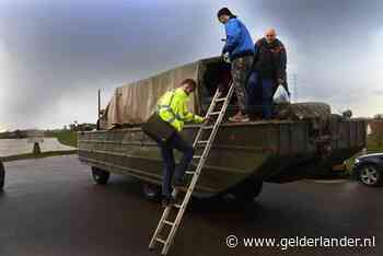 Deze mannen gaan per amfibievoertuig naar hun werk aan de Waal bij Echteld