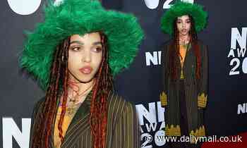 FKA twigs looks typically quirky in a green fur hat and pinstripe blazer jacket at the NME Awards
