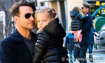 Bradley Cooper fits in a morning workout as he carries daughter Lea around New York's city streets