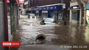 Cars filmed driving down flooded street