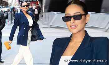 Shay Mitchell cuts a chic figure in a navy blazer worn over white outfit in New York City