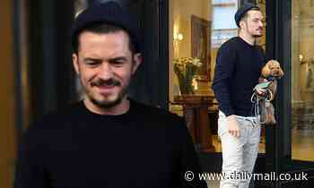 Orlando Bloom cuts a casual figure in sweats as he steps out to greet fans with pooch Mighty