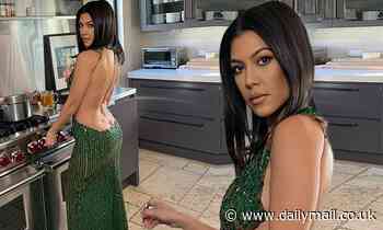 Kourtney Kardashian teases her backside as she tends to the kitchen in VERY low-backed emerald gown
