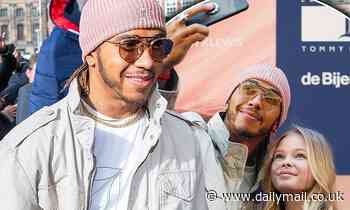 Lewis Hamilton looks dapper in a pink beanie and an all-white ensemble as he meets fans in Amsterdam