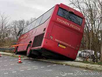 Touringcar rijdt van talud in Rhenen, geen gewonden