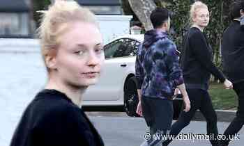 Sophie Turner shields her stomach behind denim overalls with husband Joe Jonas amid pregnancy rumors