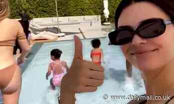 Kendall Jenner gives a thumbs up and boasts 'still no kids' at Kardashian pool party