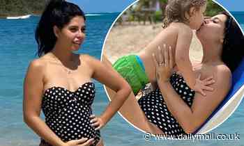 Pregnant Cara De La Hoyde proudly cradles her baby bump in a swimsuit