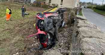 Lorry driver in hospital after crashing through wall and overturning