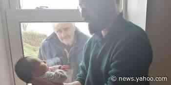 Grandfather meets newborn grandson through a window in heartbreaking photo