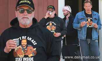 Arnie ignores his own advice as he wears 'stay inside' hoodie while enjoying coffee at cafe