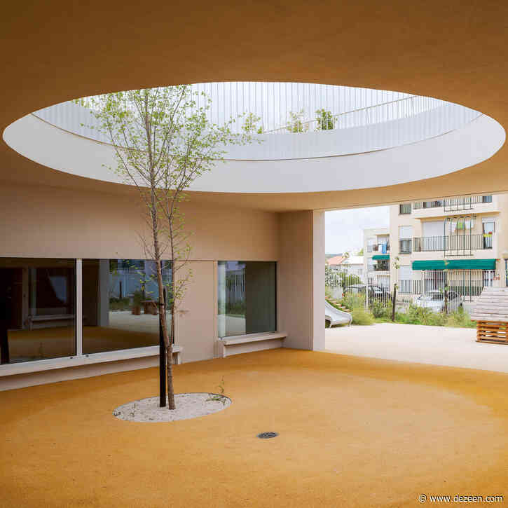 Circular holes connect playgrounds on two levels of a Lisbon school
