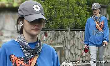 Lucy Hale cuts a casual figure in sweater and baseball cap as she heads out on dog walk