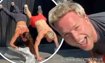 Olly Murs and his bodybuilder girlfriend Amelia Tank take part in viral T-shirt handstand challenge 