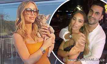 Lauren Pope displays her baby bump as she cuddles her pet pooch while soaking up the sun at home