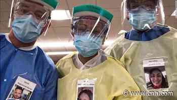 Medical workers connect with patients by wearing pictures of themselves over protective gear - CNN