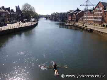 Rower on homemade boat enjoys city in the sunshine