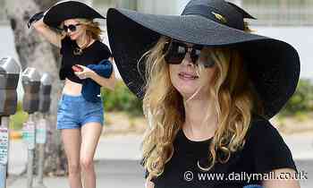 Heather Graham, 50, is an ageless beauty in Daisy Dukes and a black crop top during stroll