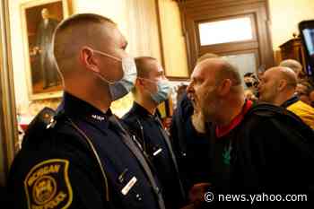 Hundreds of protesters, some carrying guns in the state Capitol, demonstrate against Michigan's emergency measures
