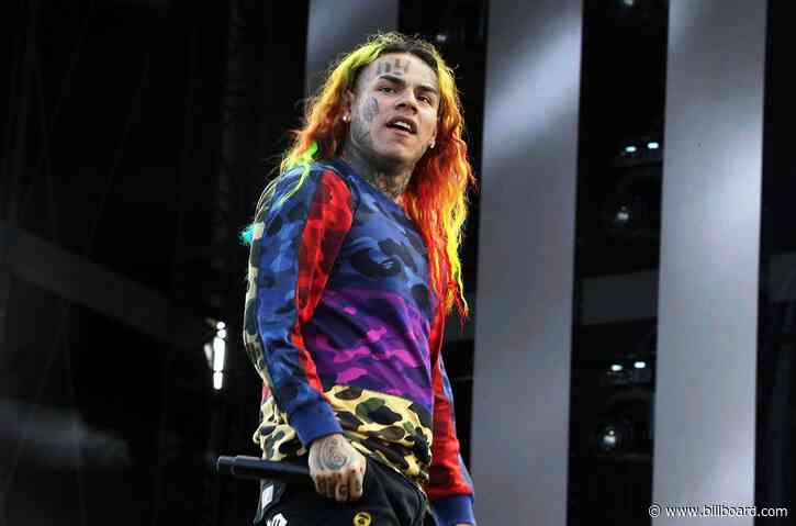6ix9ine Flashes ‘$1 Million’ Jewelry & Stacks of Cash from House Balcony: Watch