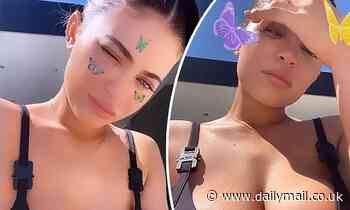Kylie Jenner poses in a black bikini top as she says she is enjoying another 'pool day'